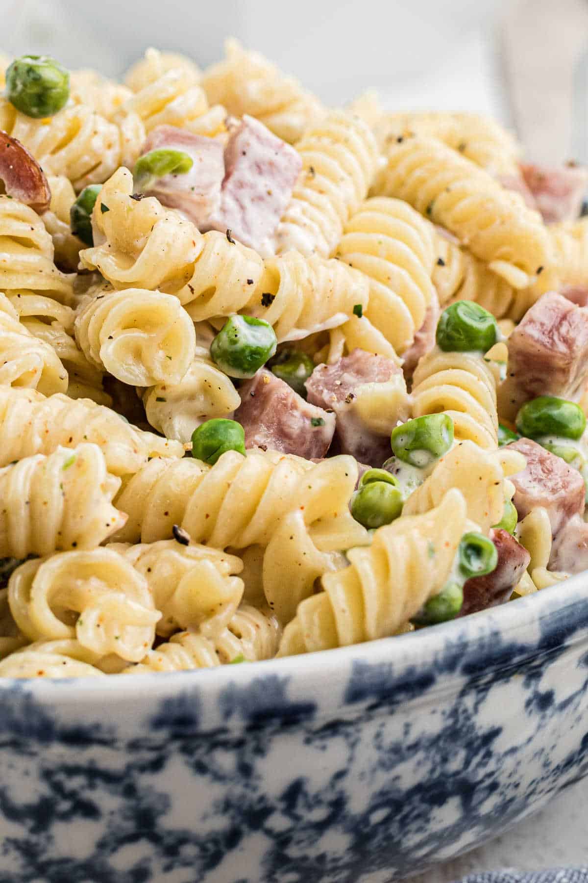 Very close up side shot of a bowl of Ruby Tuesday ham and pea pasta salad.