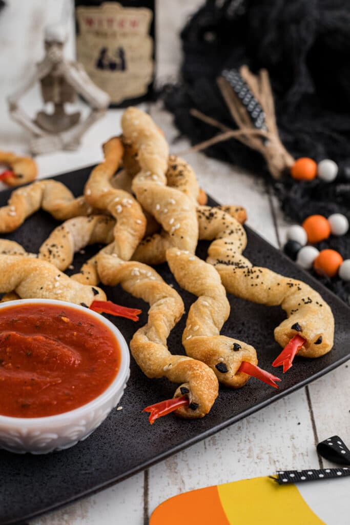 A side angled shot of a plate full of breadstick rattlers for Halloween.