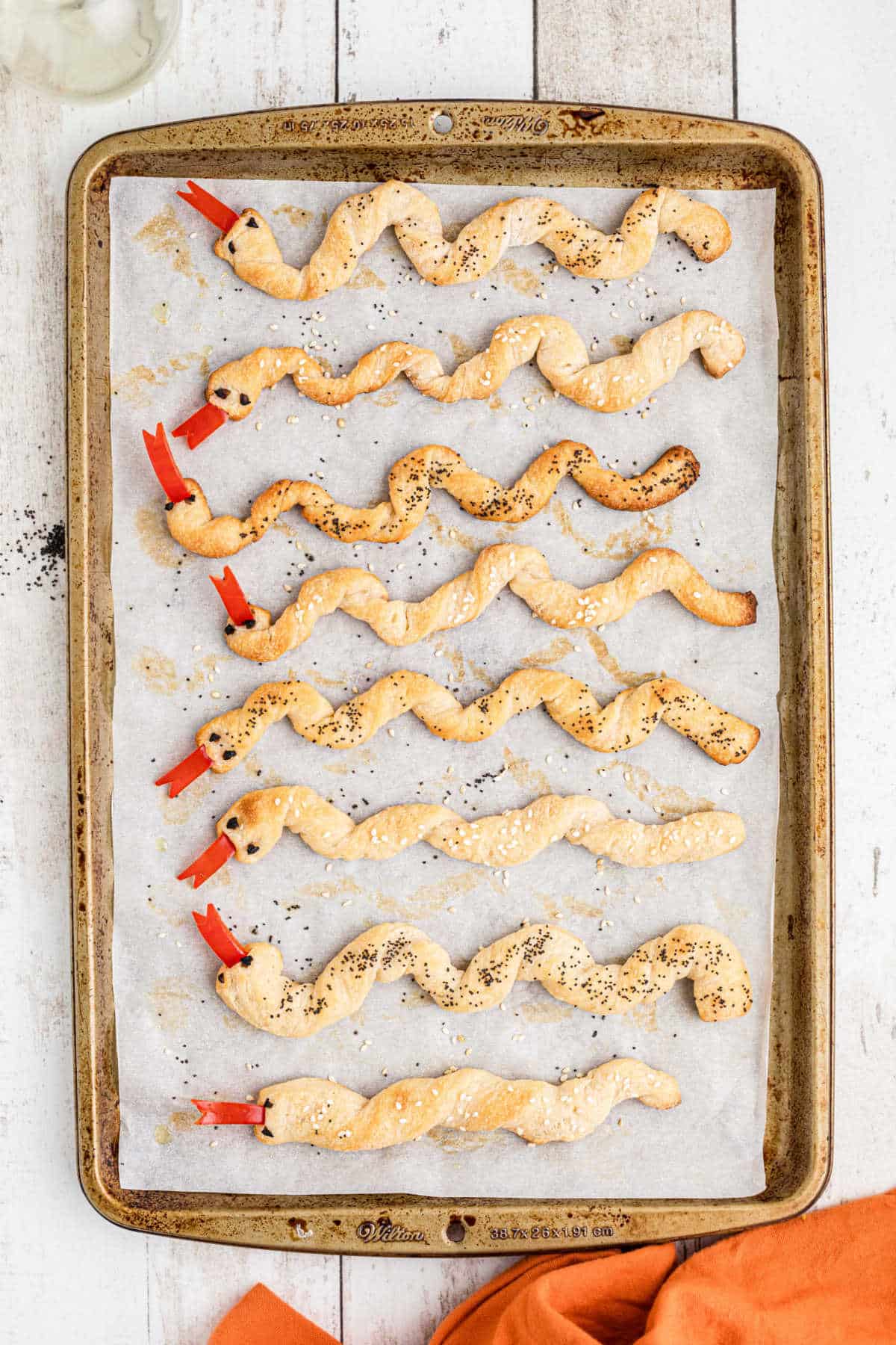 A baking sheet with finished breadstick snakes.