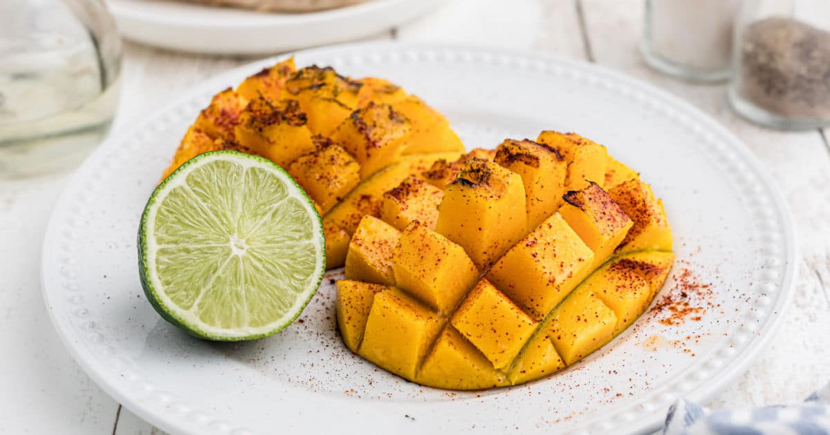 Close up of some grilled mango with a slice of lime.