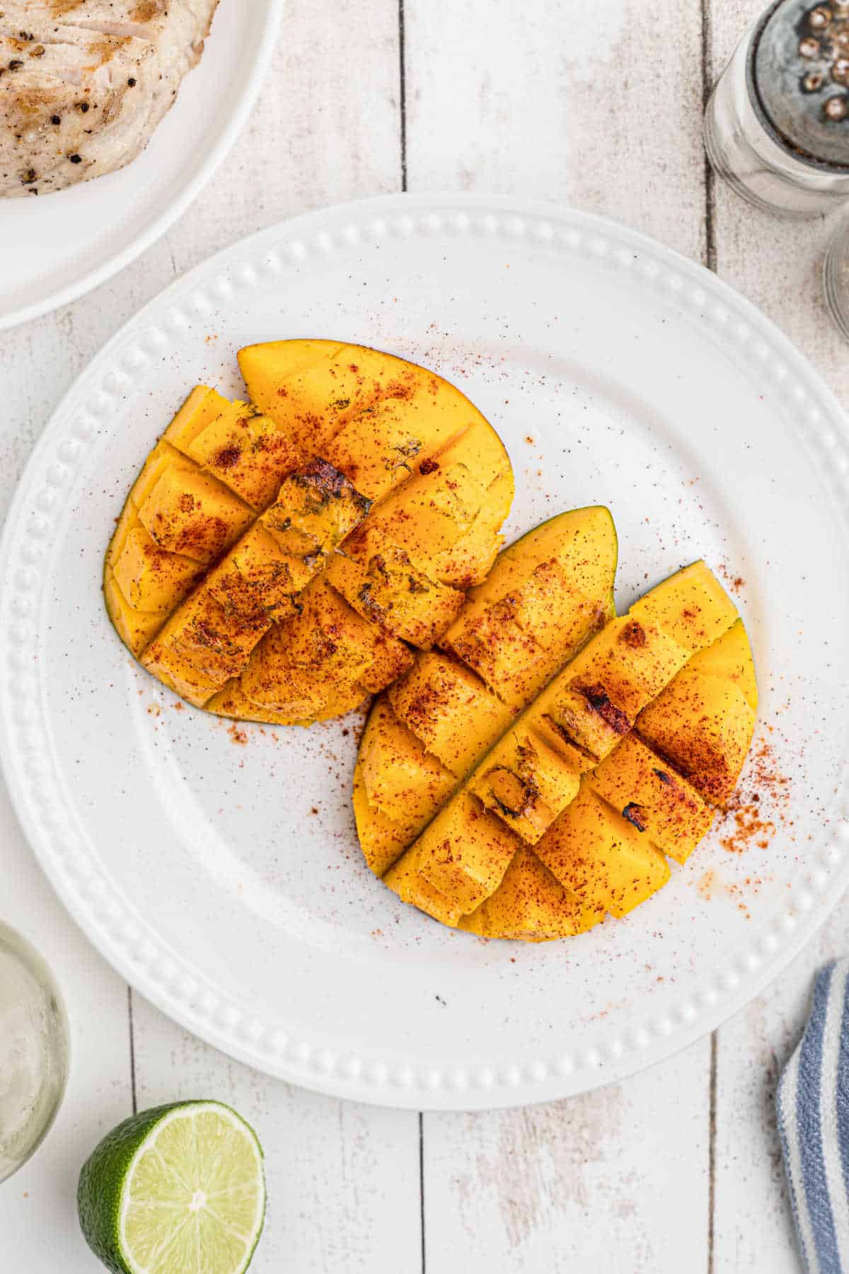 Two halves of grilled mango on a plate.