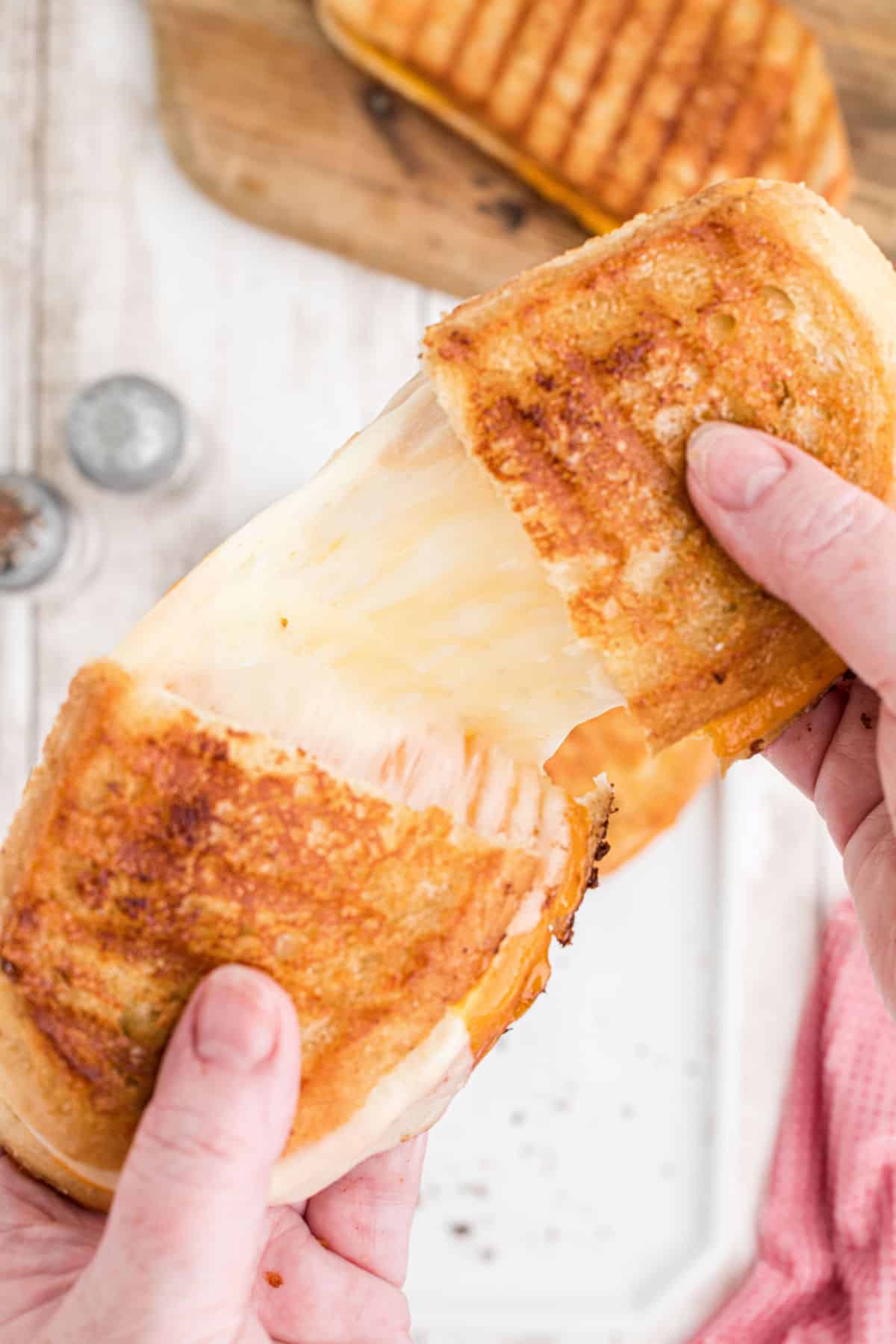 A Starbucks grilled cheese being pulled apart and all cheesy.