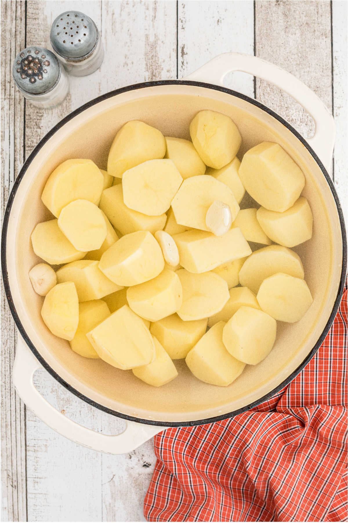 Peeled potatoes and garlic in a large Dutch oven pot.