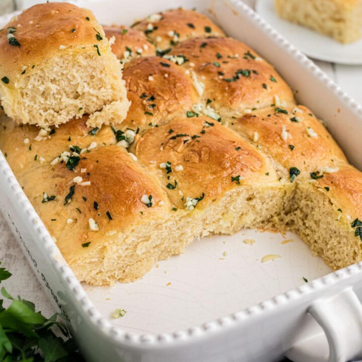 A baking dish with garlic butter rolls just cooked.