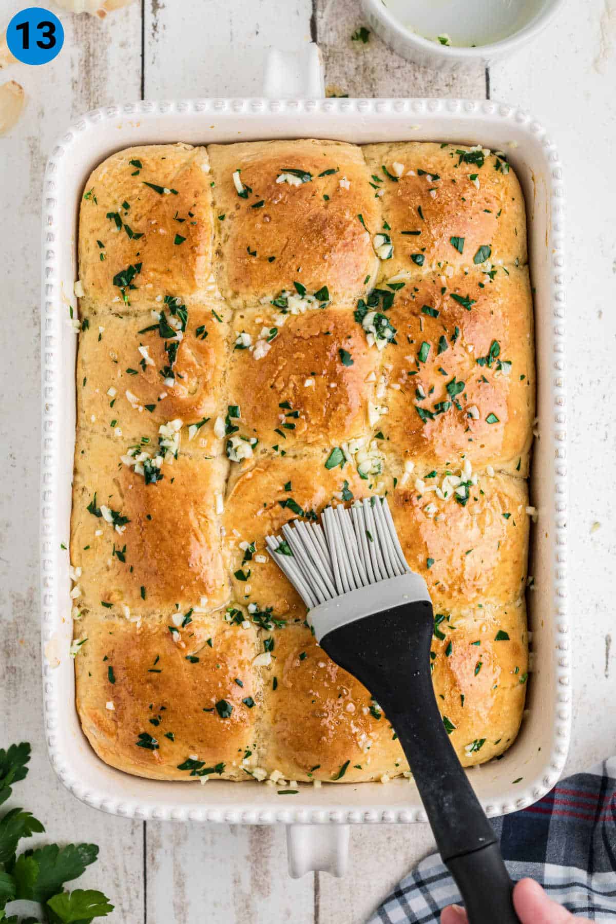 Garlic Butter Rolls being brushed with garlic butter and parsley.