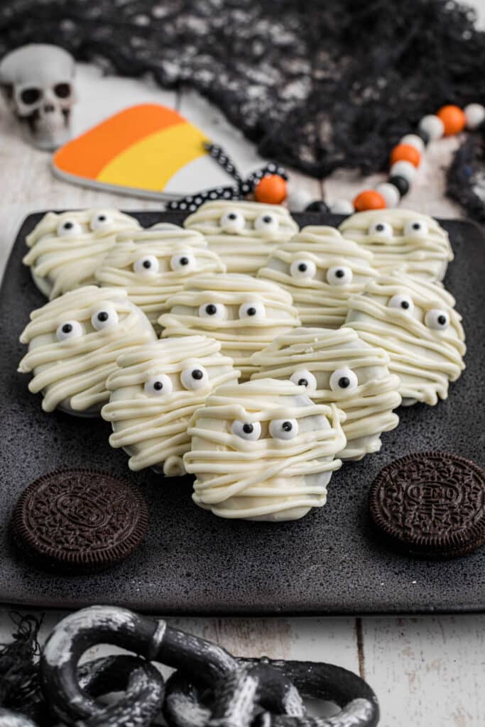 Mummy Oreos stacked against each other and decorated for Halloween.
