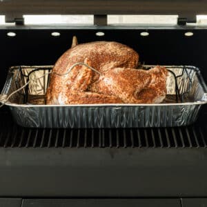 A cropped square image showing a pellet grill smoked turkey.