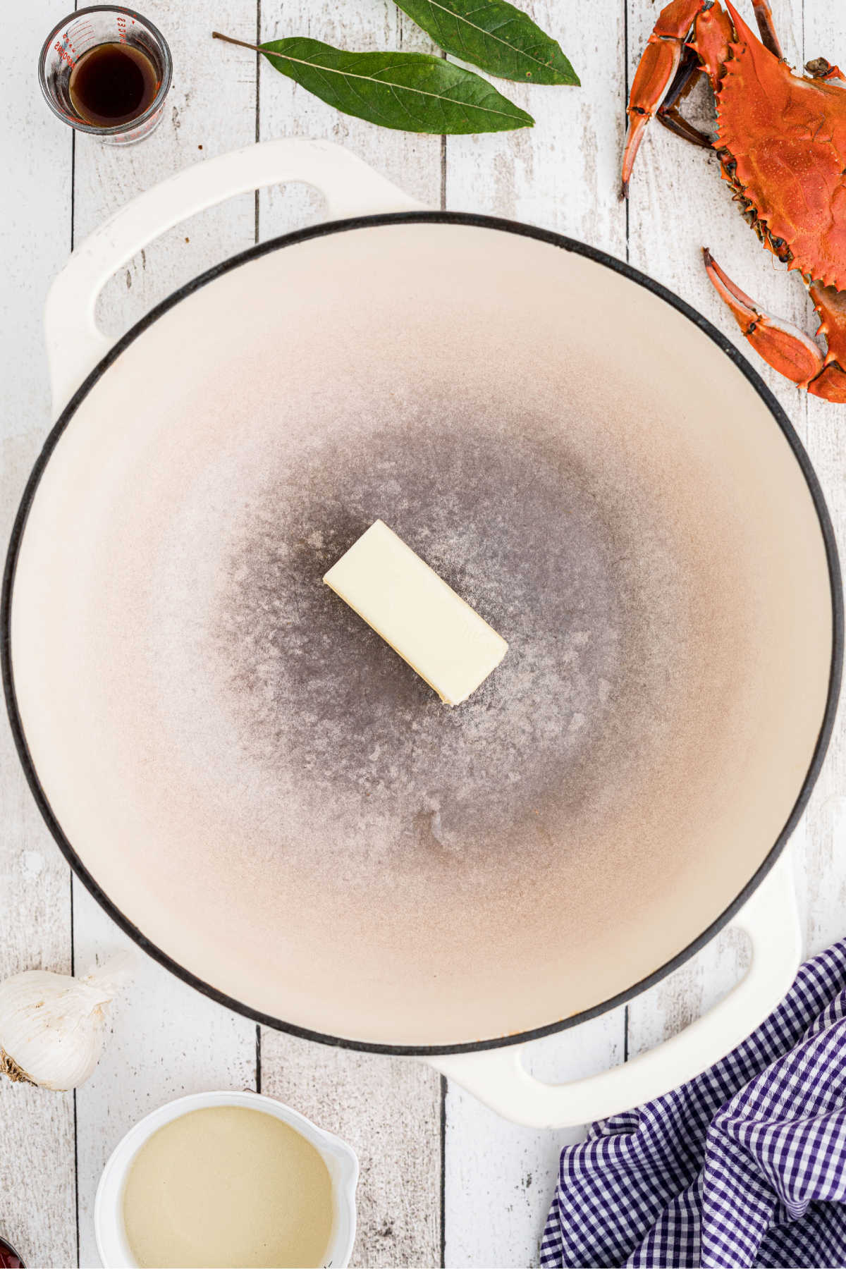 A large Dutch oven with a stick of butter in it.