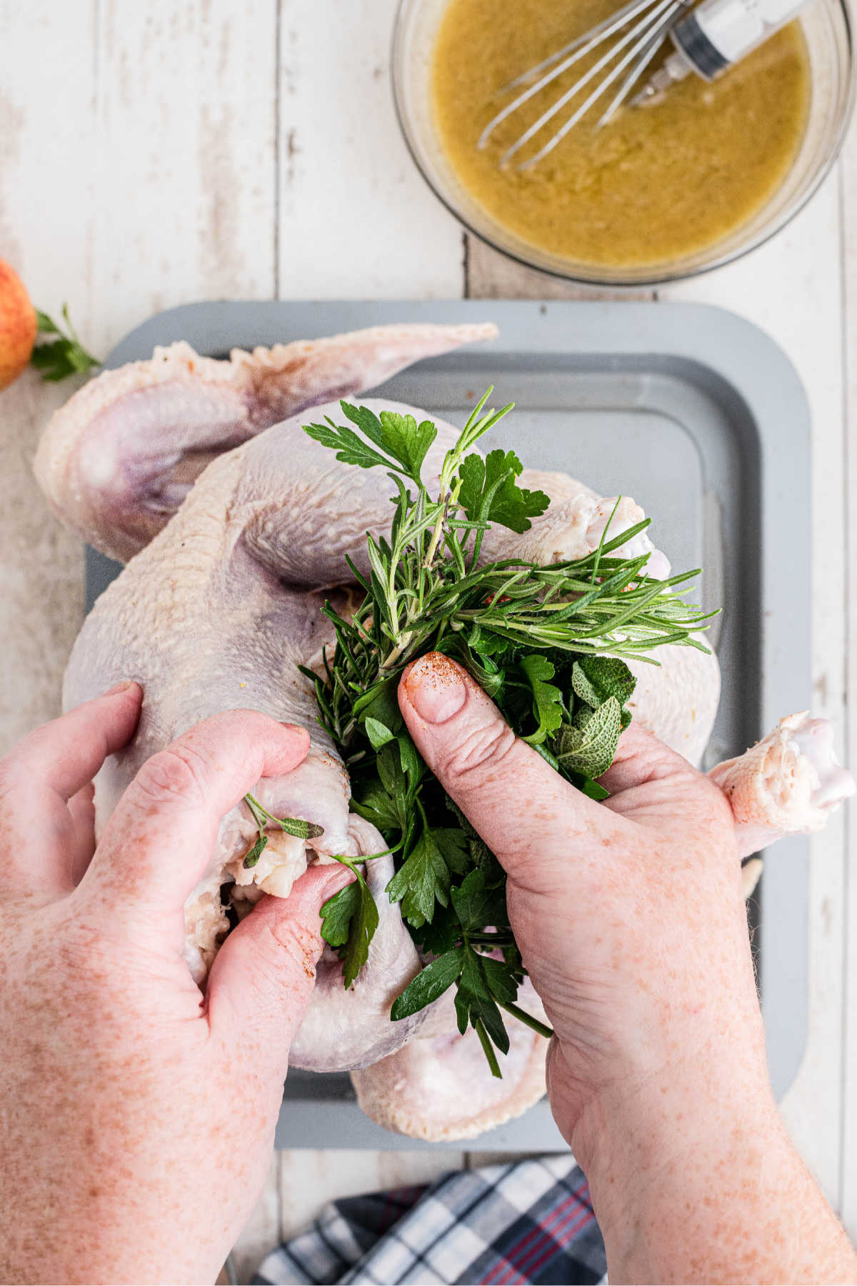 Greens being stuffed into a turkey.