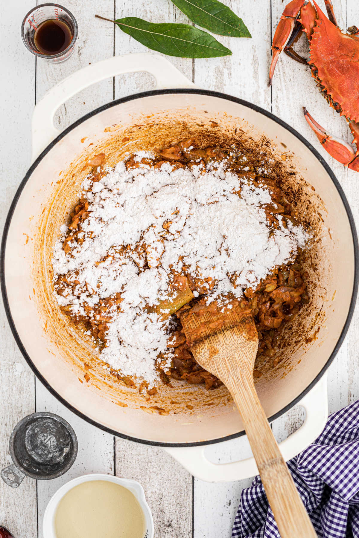Flour added to a pot with cooked vegetables.