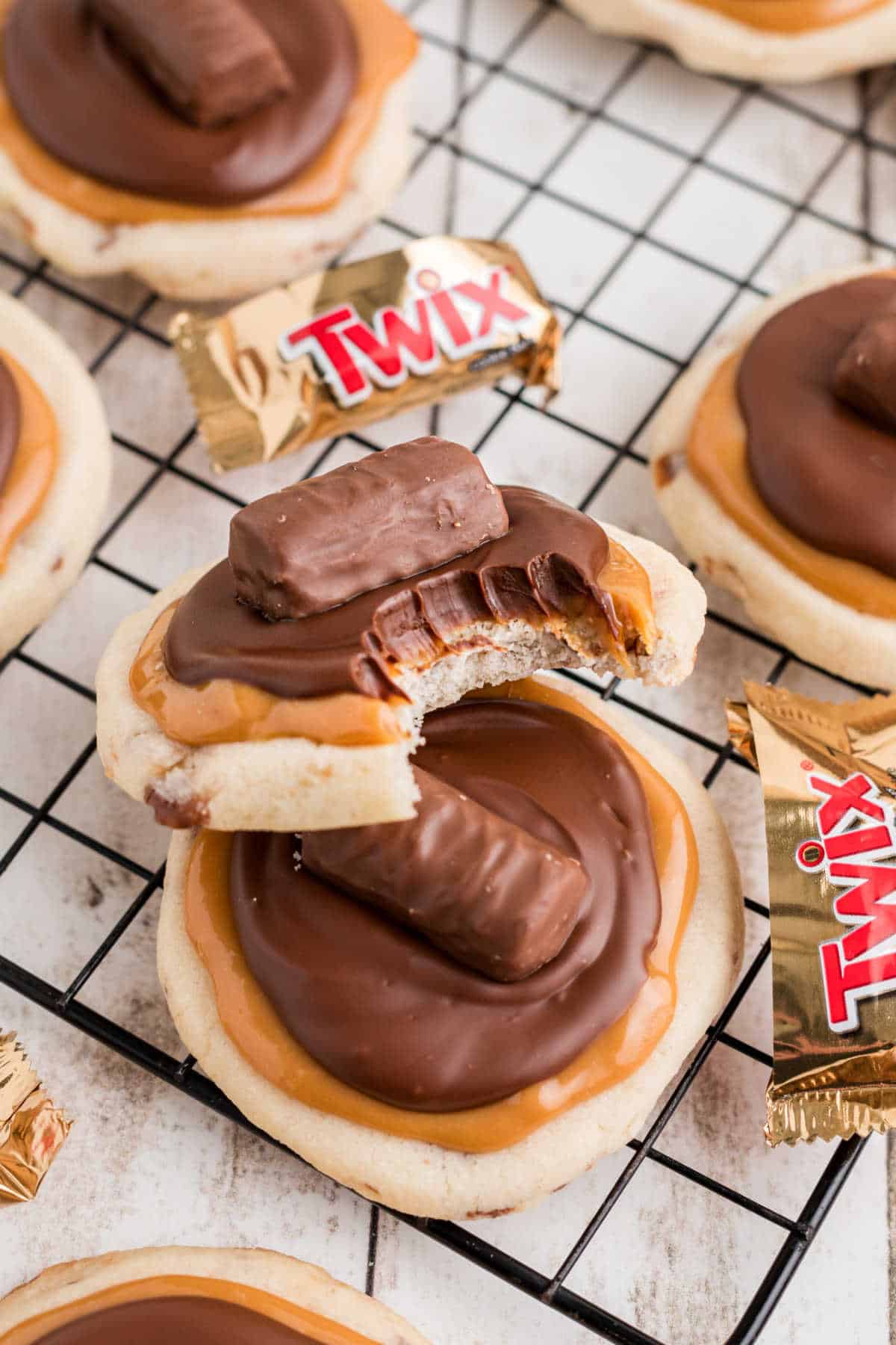 Close up of a Crumbl Twix Cookies recipe, one with a bite taken out.