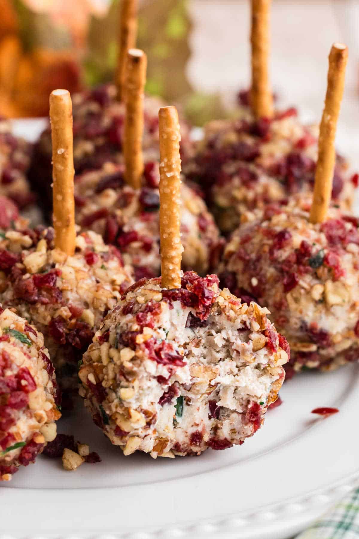 Close up of a cranberry pecan cheese ball bites with a bite taken out of the front one.