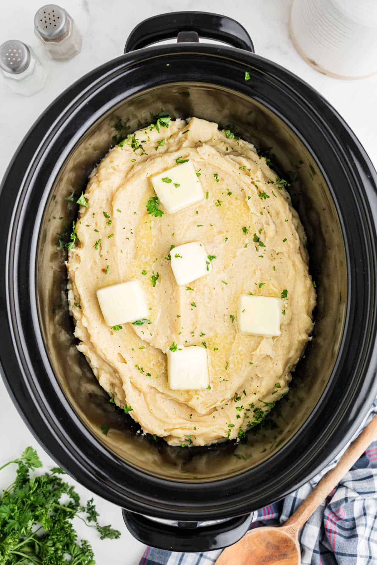 Overhead image of a slow cooker with mashed potatoes made with chicken broth.