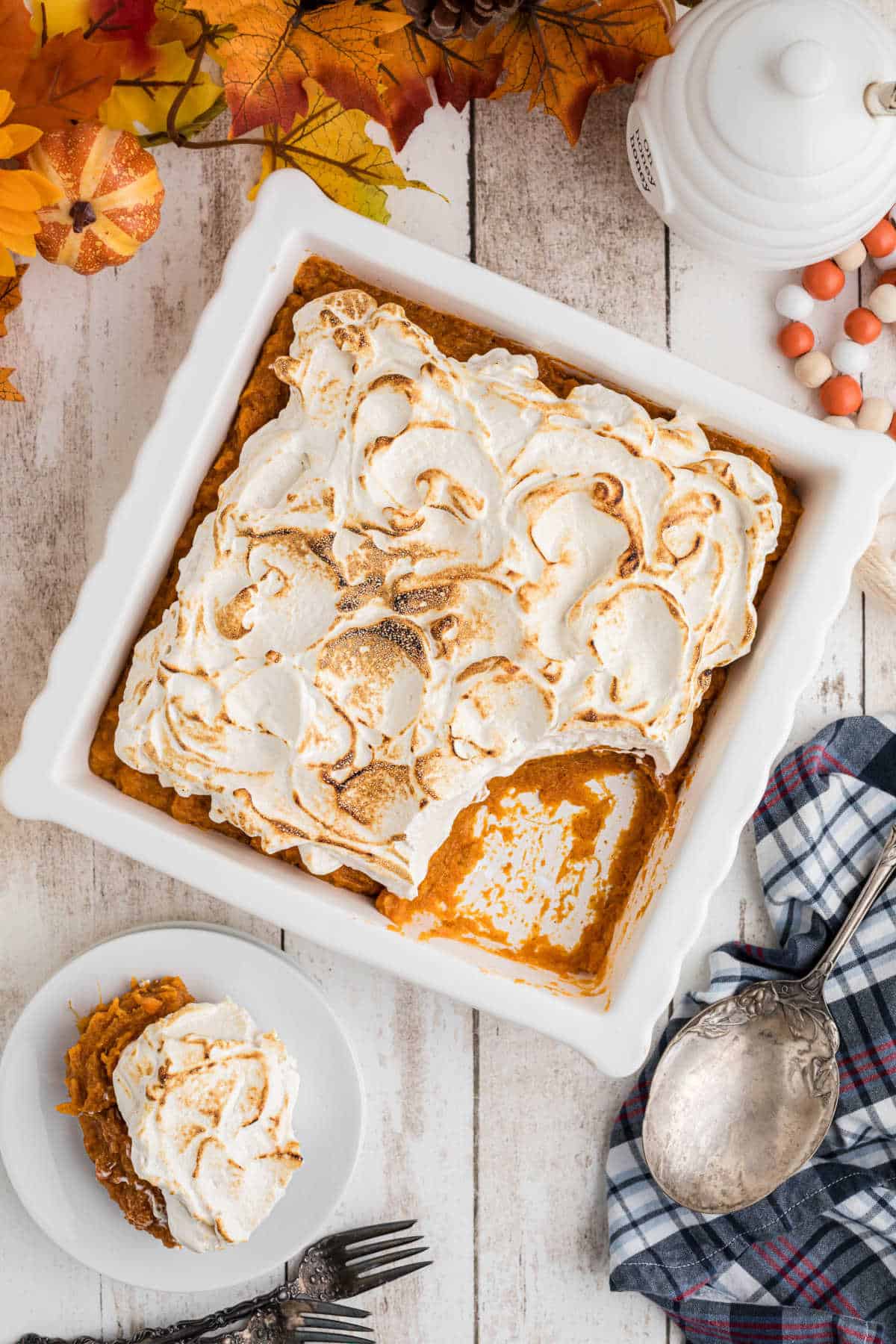 Overhead shot of a sweet potato fluff in a square dish with a spoon missing.