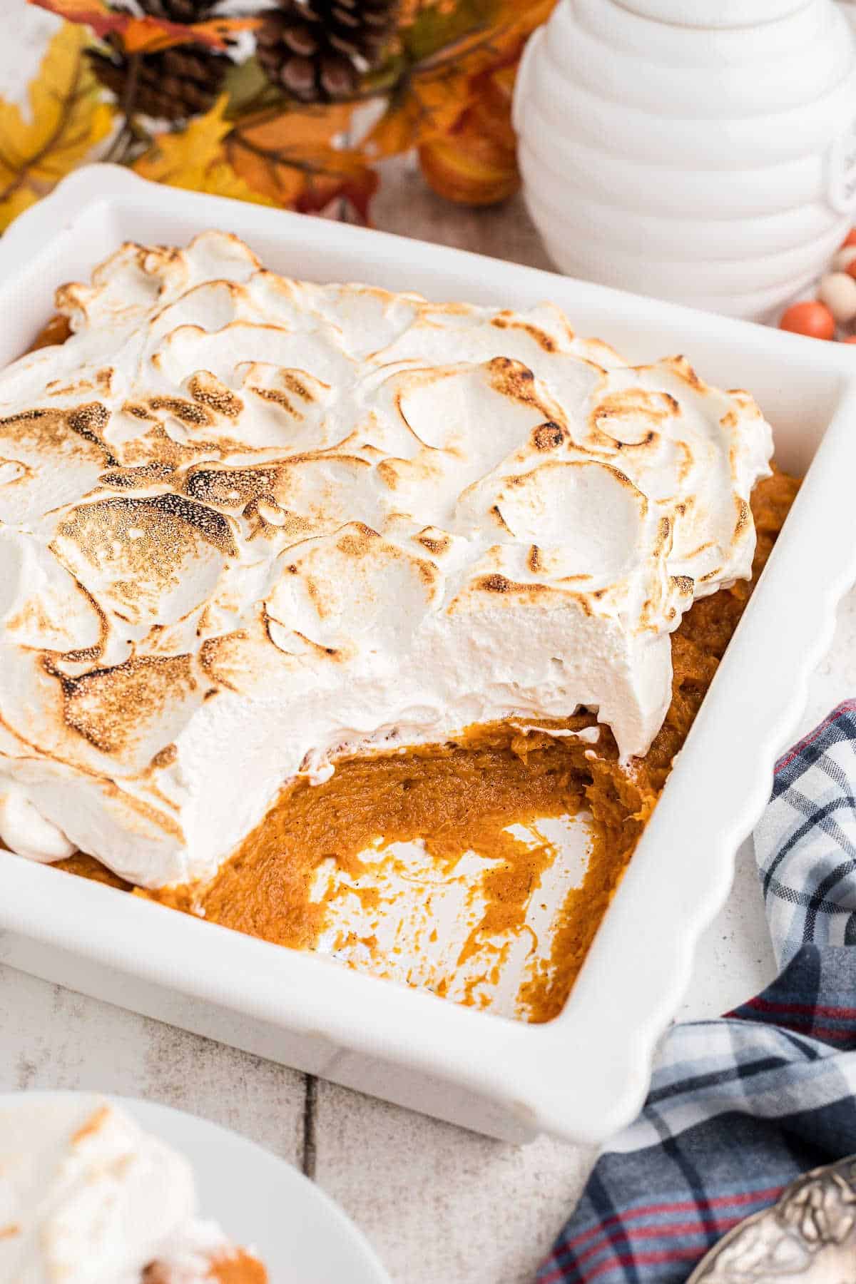 Side shot of a dish of sweet potato fluff with a scoop missing.