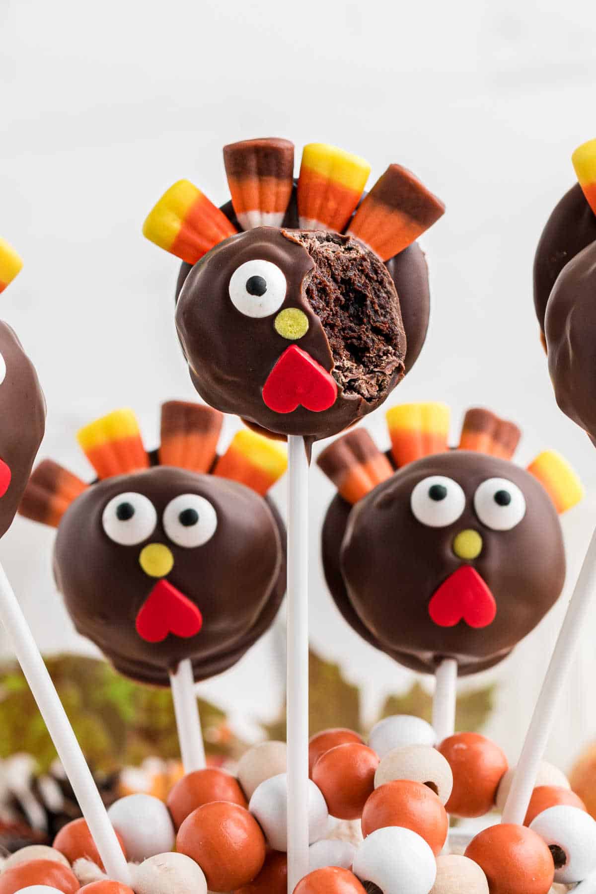 Close up of a thanksgiving cake pop recipe, a thanksgiving turkey cake pop with a bite taken out.