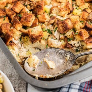 A cropped square image of Amish turkey stuffing recipe, with a spoon resting.