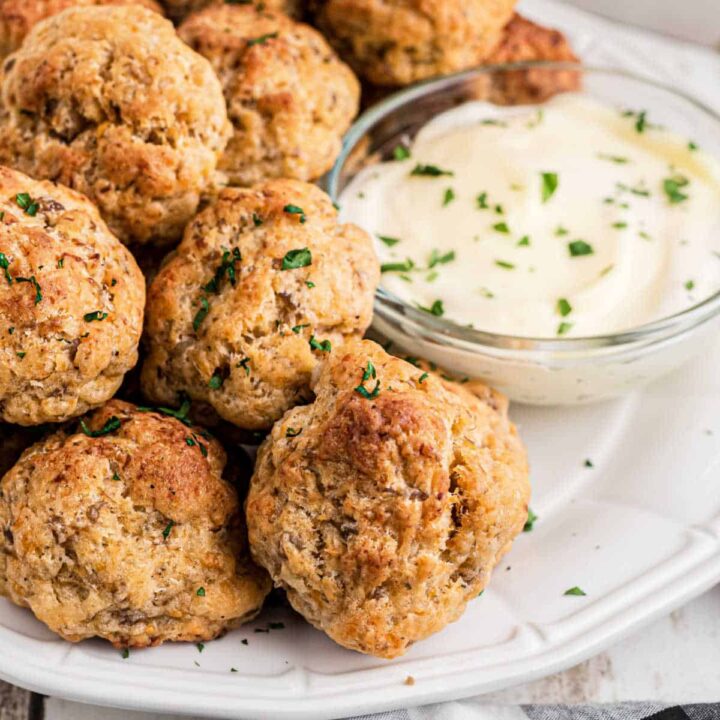 Close up of some cheddar bay sausage balls with ranch in a bowl.