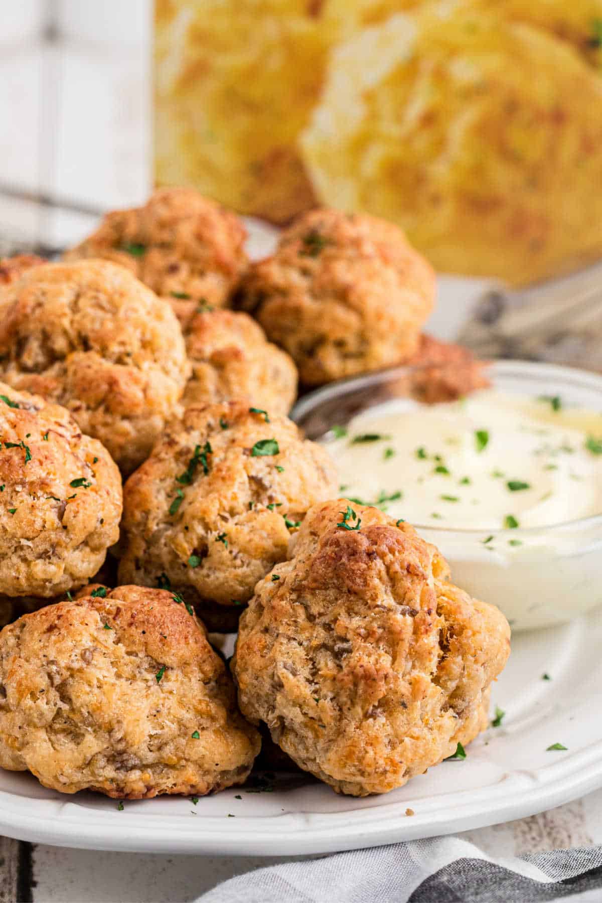 Side angled shot of a plate full of cheddar bay sausage balls.