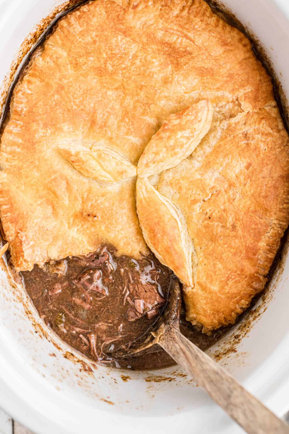Overhead shot of a slow cooker steak pie recipe with a spoon sitting in it.