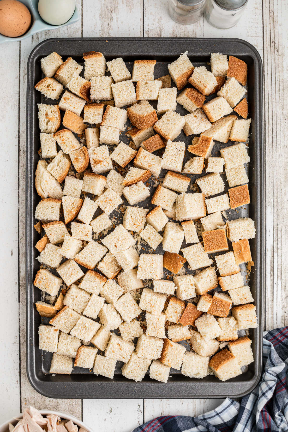 Cubes of bread laid out on a baking sheet.