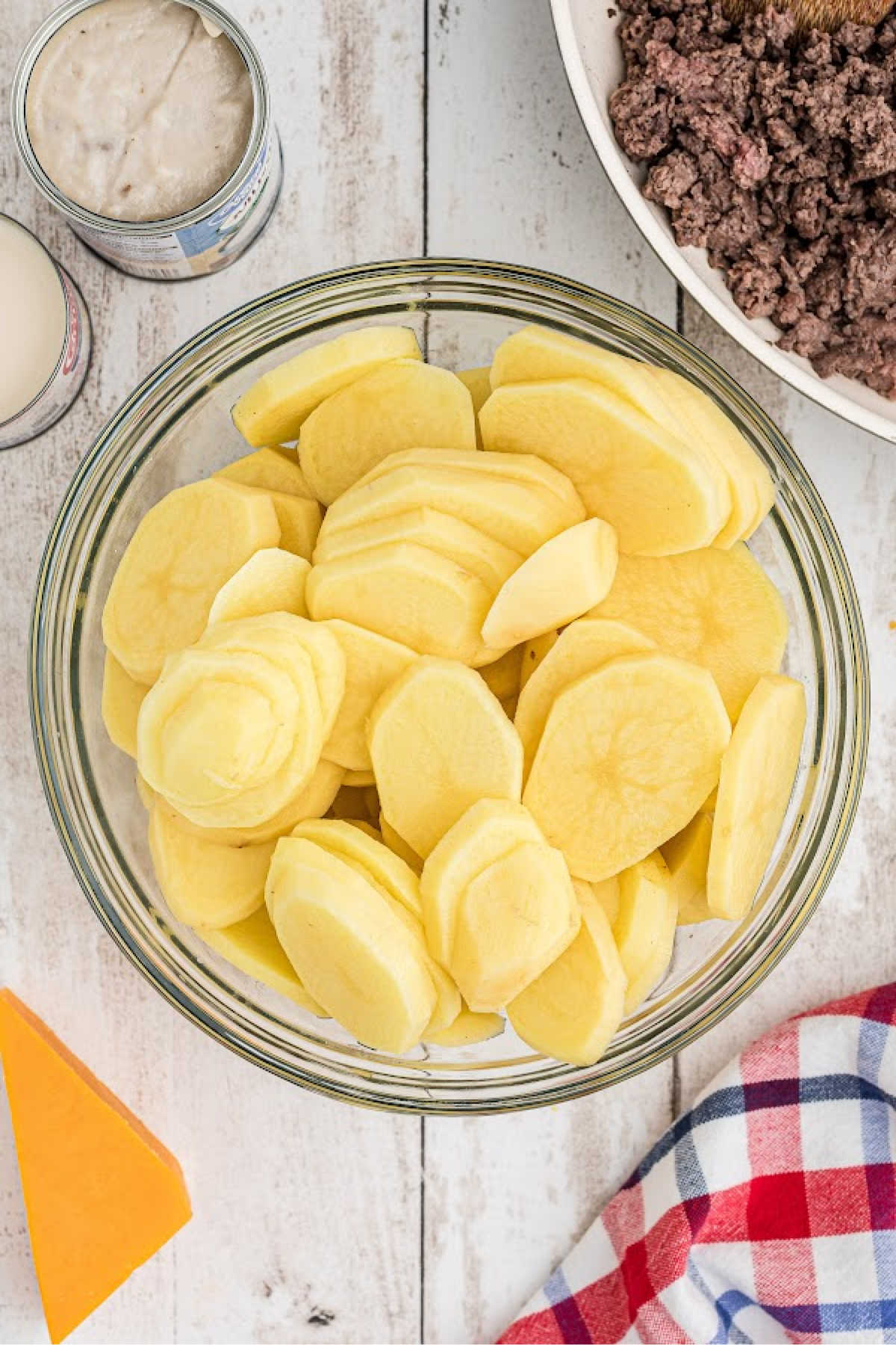 Sliced potatoes in a large mixing bowl.