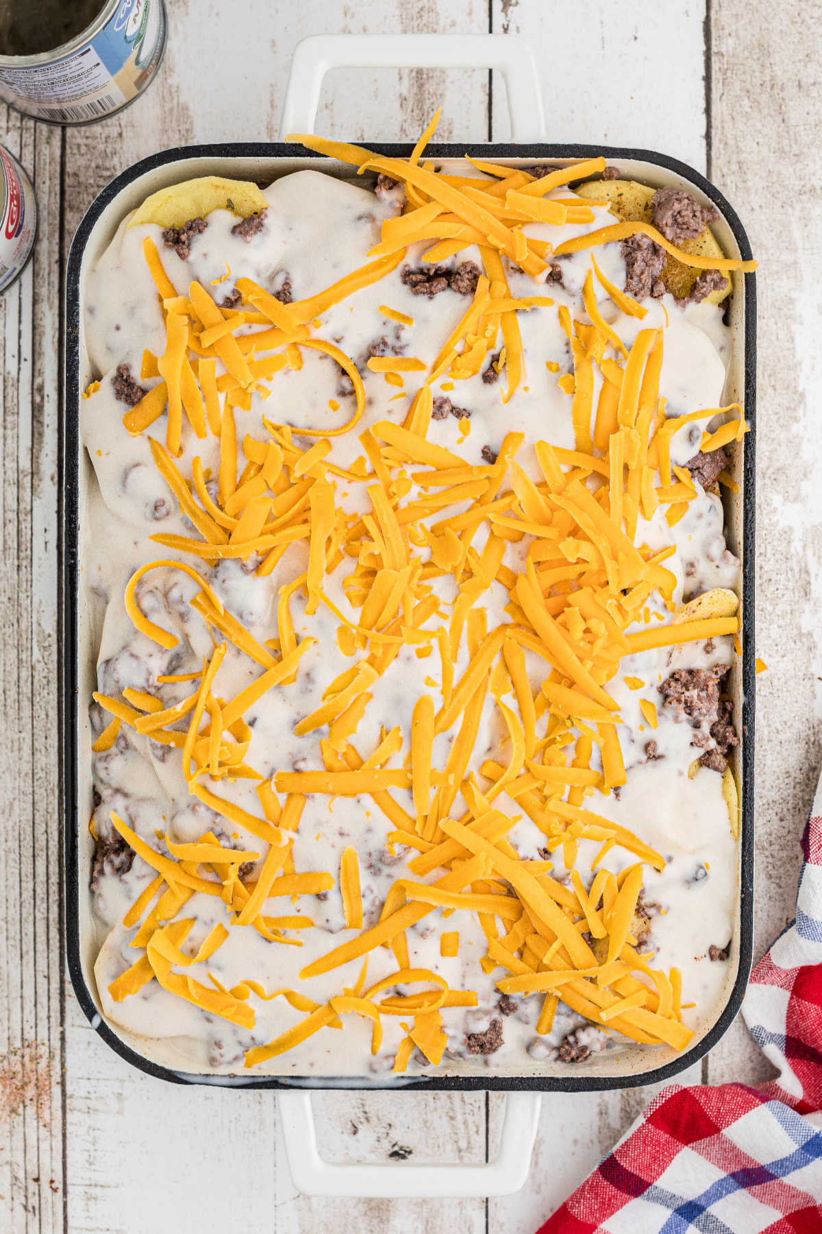 Grated cheese sprinkled on top of a casserole. about to be baked.