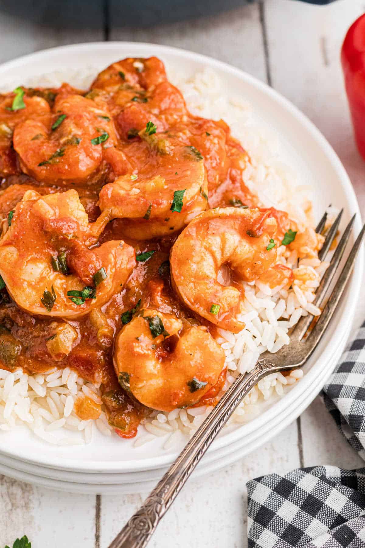 Close up of a plate of New Orleans Shrimp Creole over rice with a fork digging in.