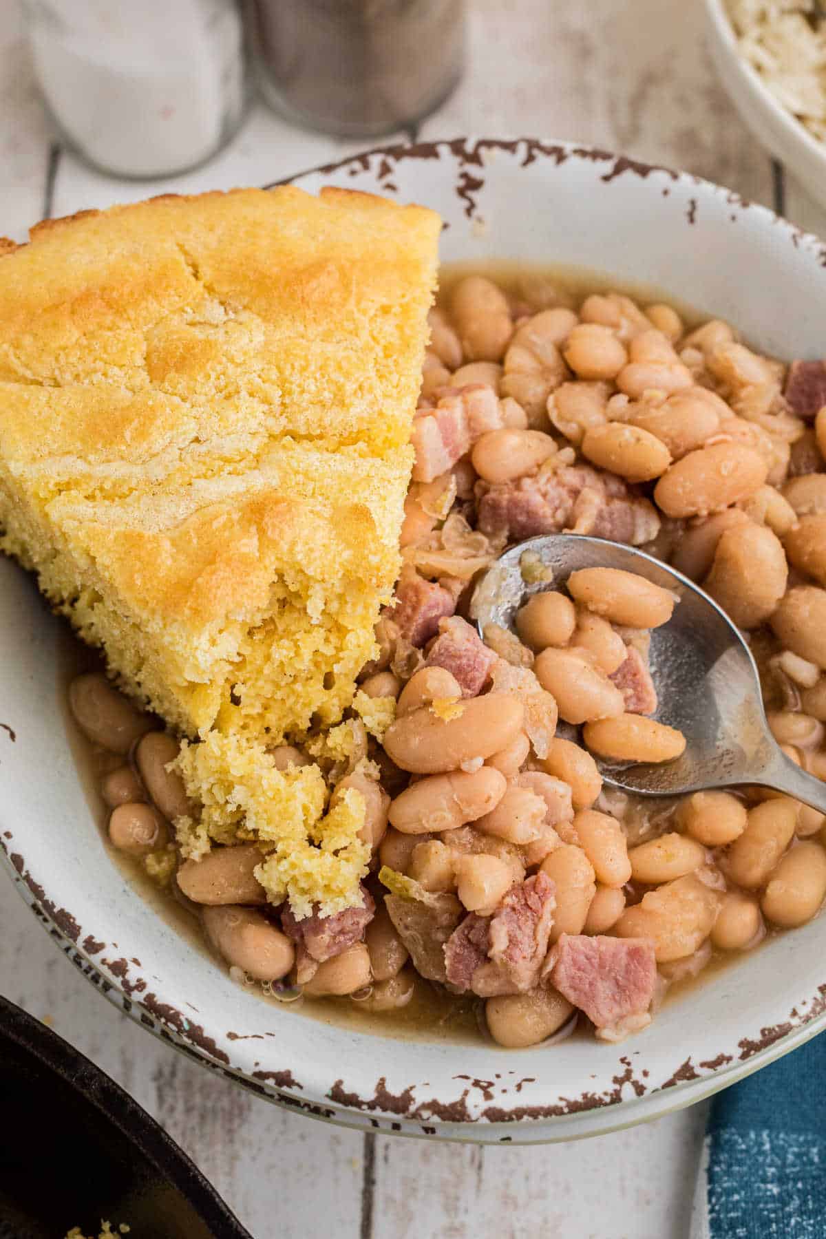 Close up of a bowl full of southern great northern beans with a slice of cornbread on the side.