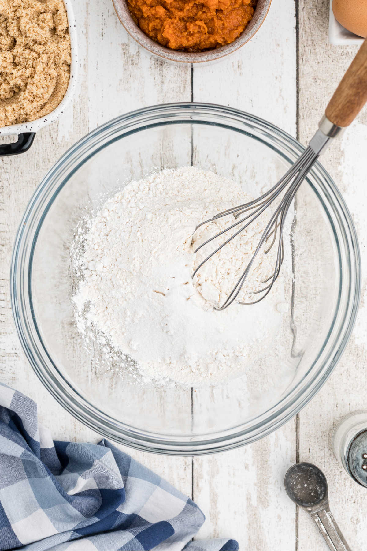 A mixing bowl, with flour and sugar. to be mixed with whisk.
