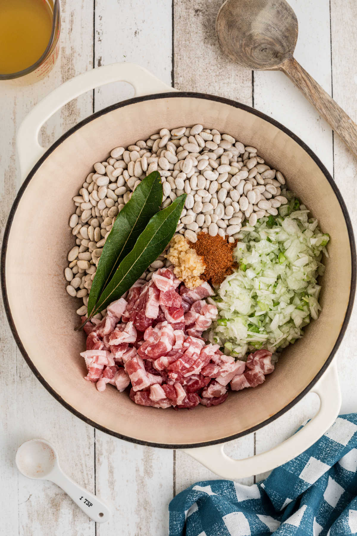 A large Dutch oven full of ingredients that will make a southern great northern beans recipe.