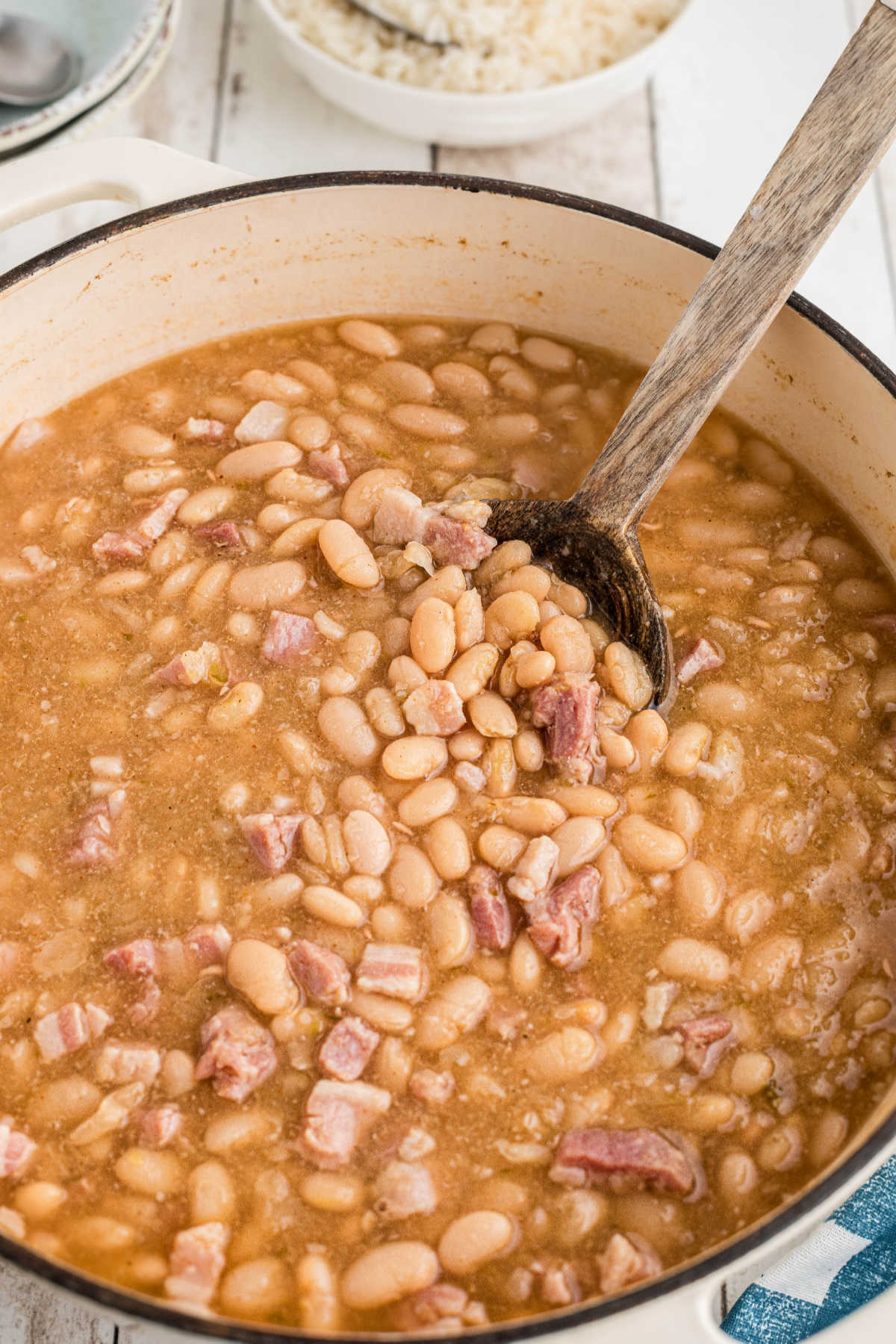 A large pot of Southern Great Northern Beans with a spoon digging in.