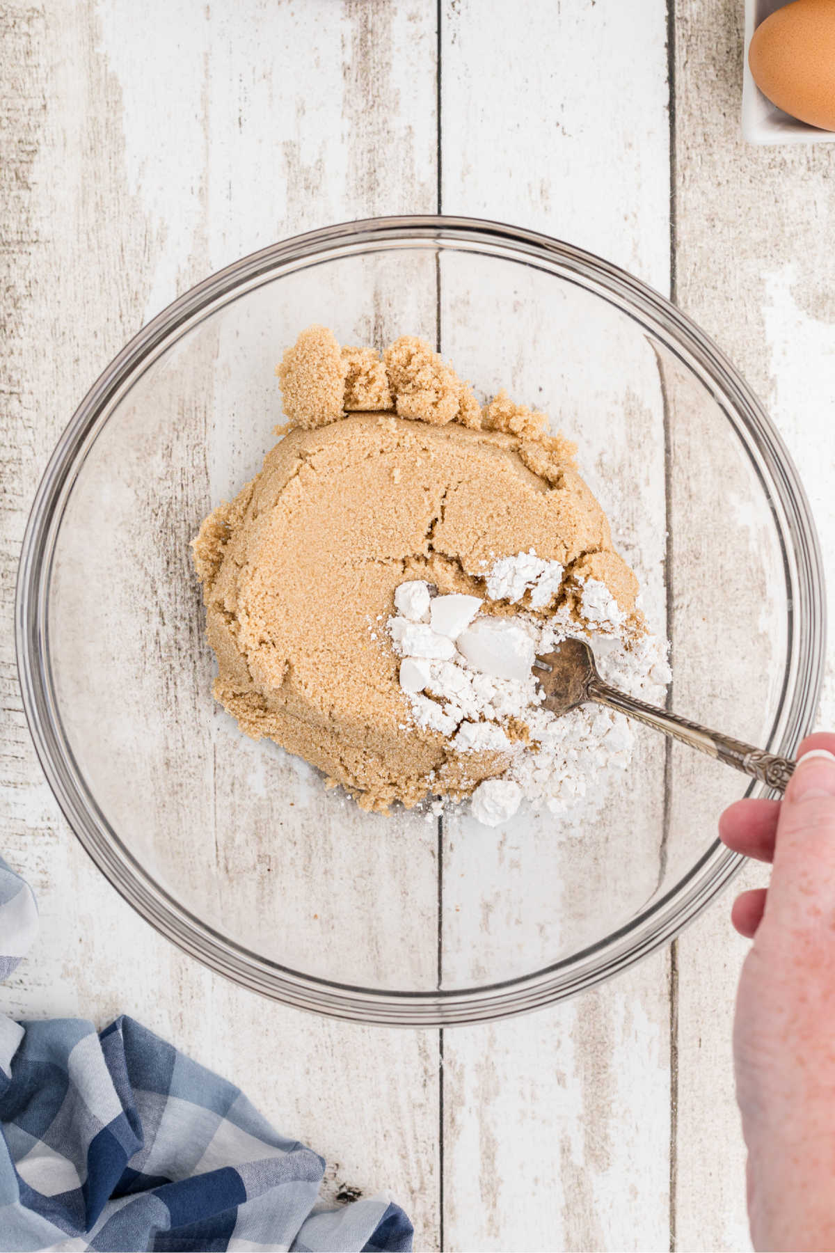 Brown sugar and flour being mixed in a bowl.