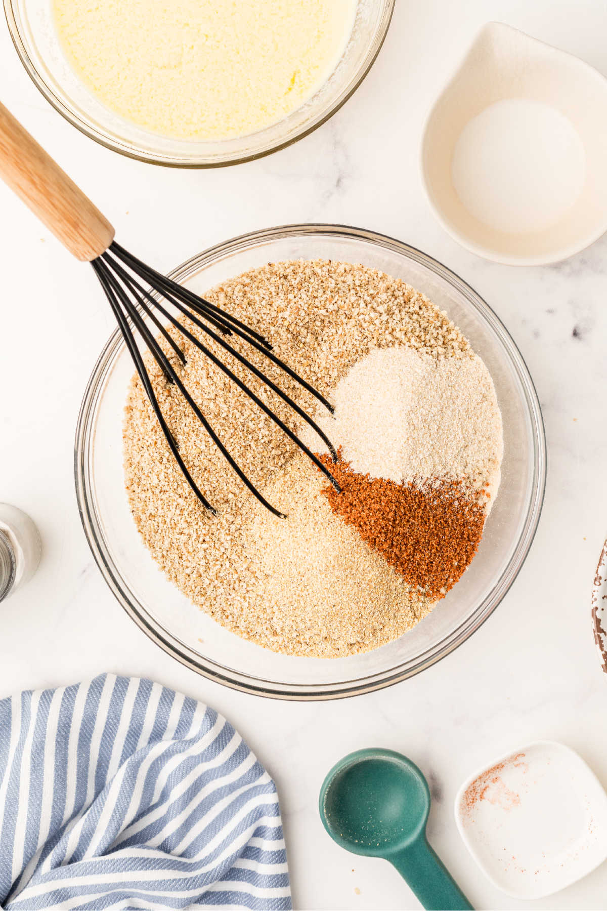 A mixing bowl full of breadcrumbs and seasonings.