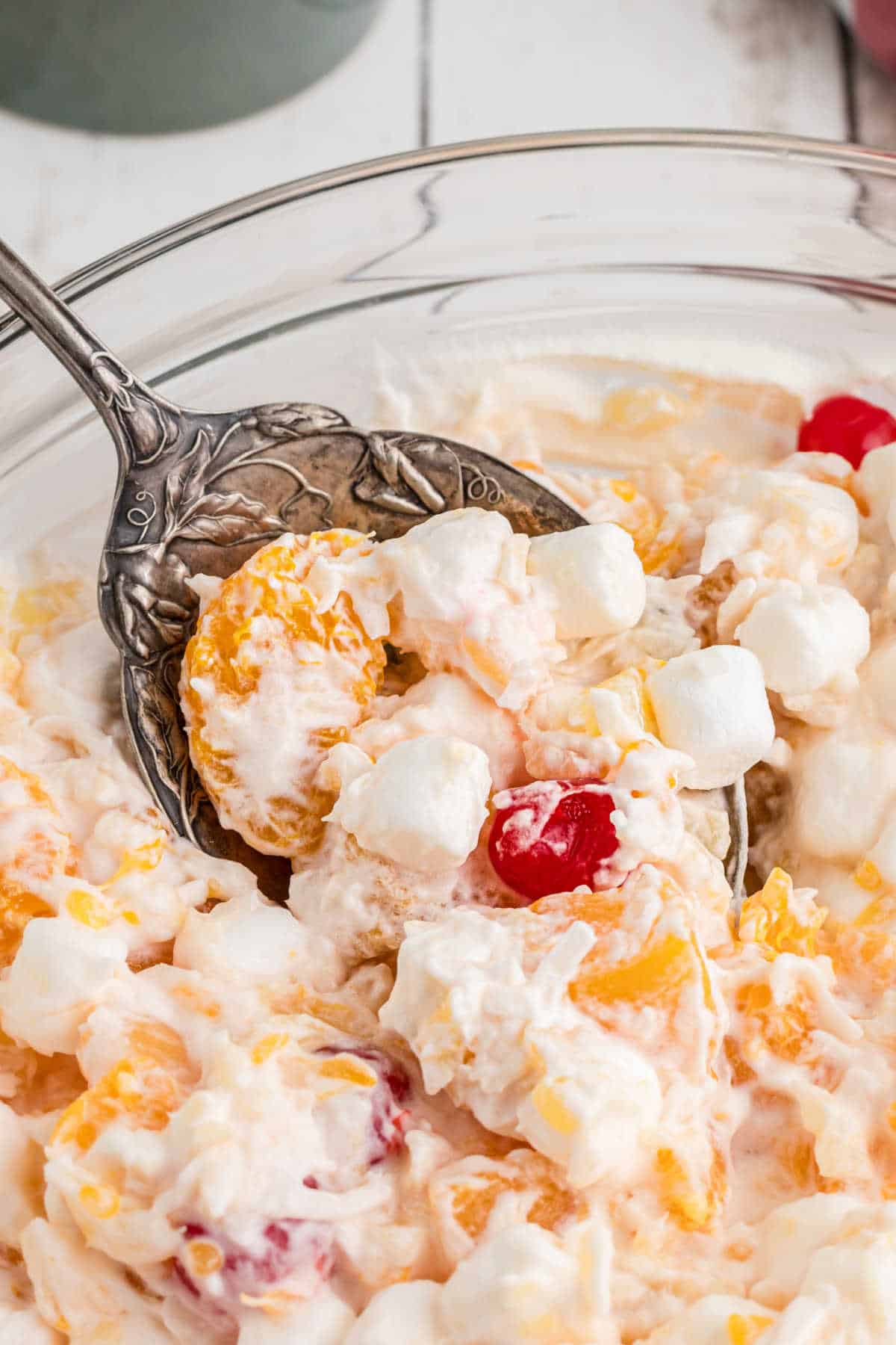 Close up of a spoon digging into old fashioned southern ambrosia salad.