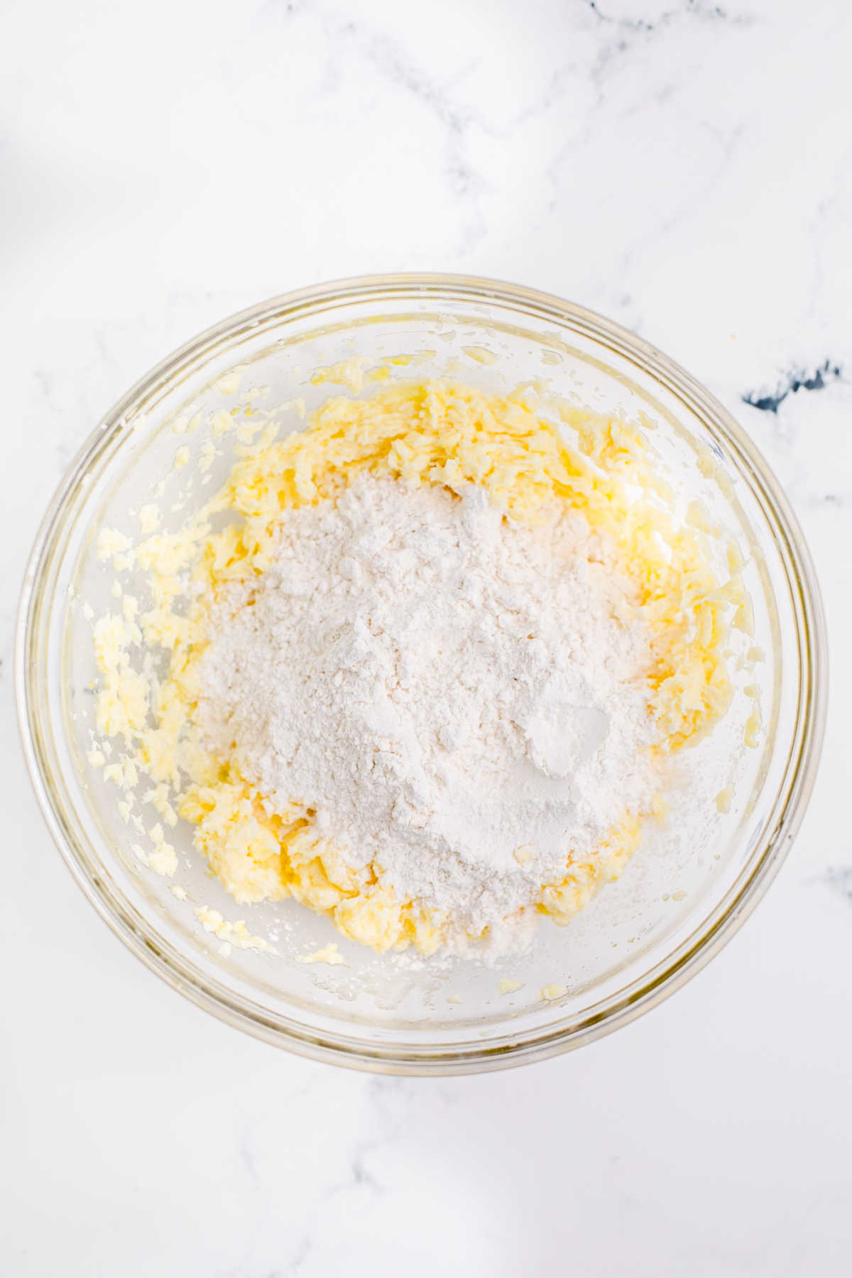 Overhead shot of a mixing bowl with butter, sugar and flour mixture.