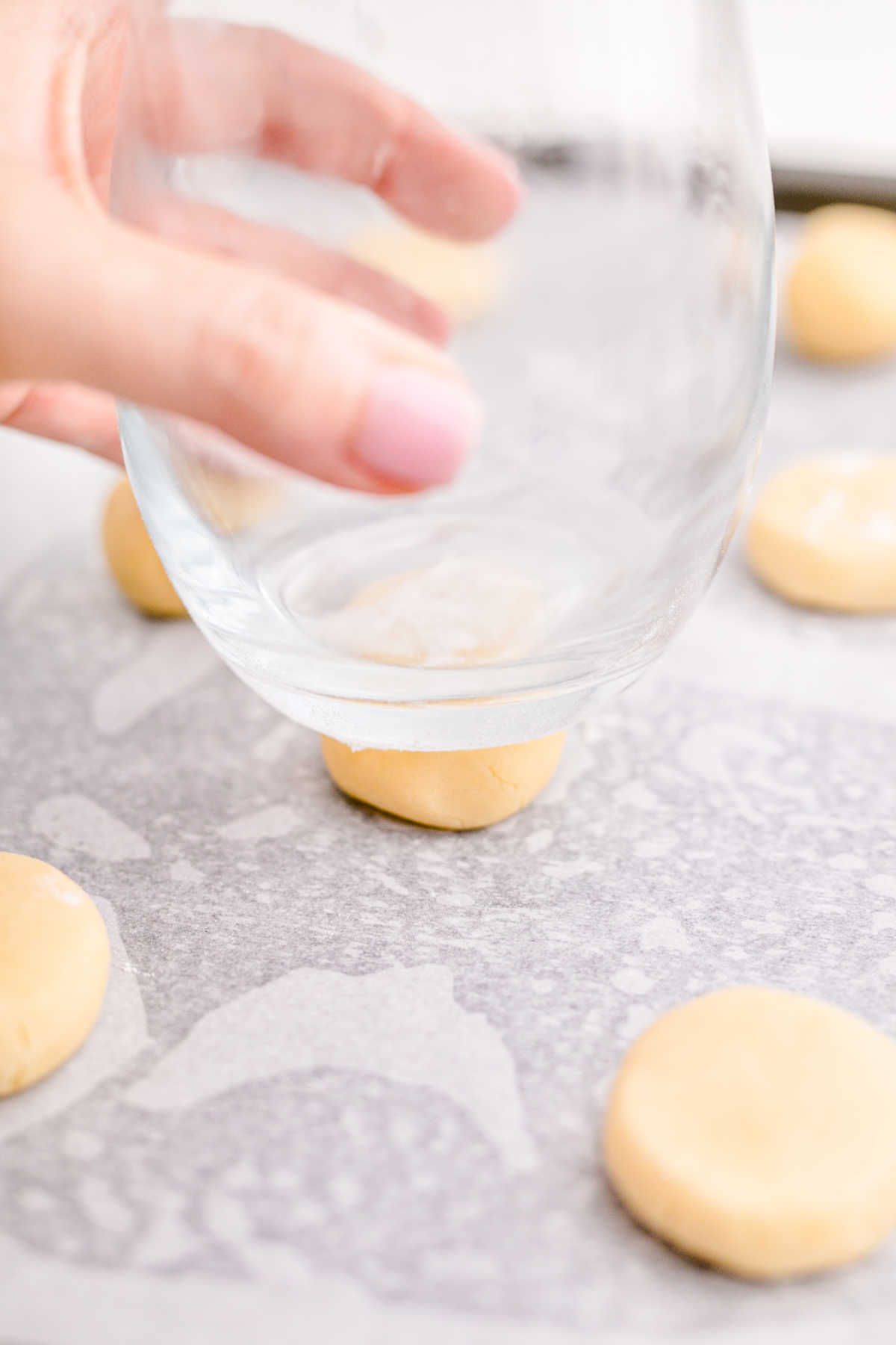 A glass pushing down on cookies.