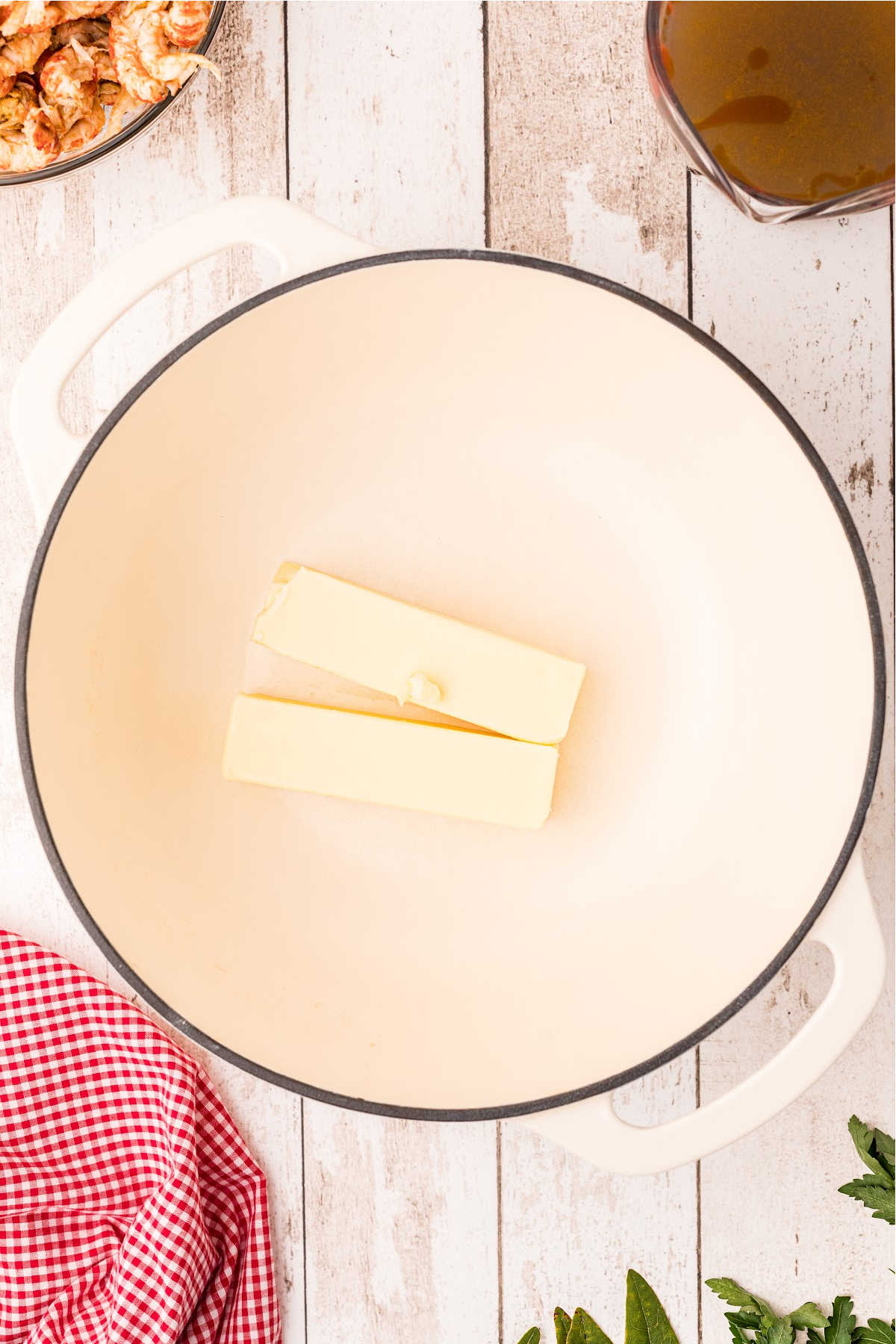 An overhead view of a large Dutch Oven with some butter.