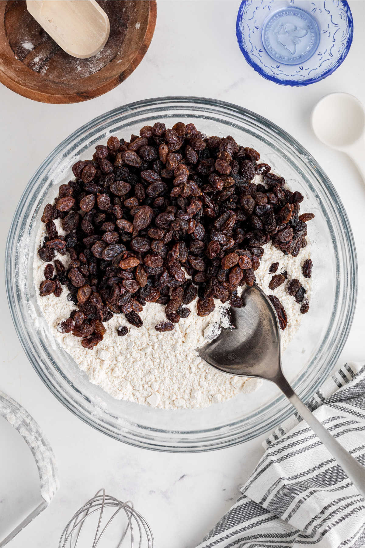Raisins being stirred into a bowl of flour.