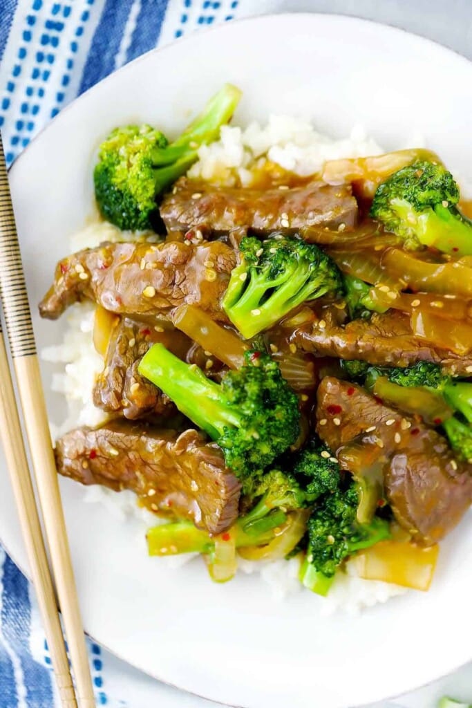 Close up shot of some chinese beef and broccoli with chopsticks.