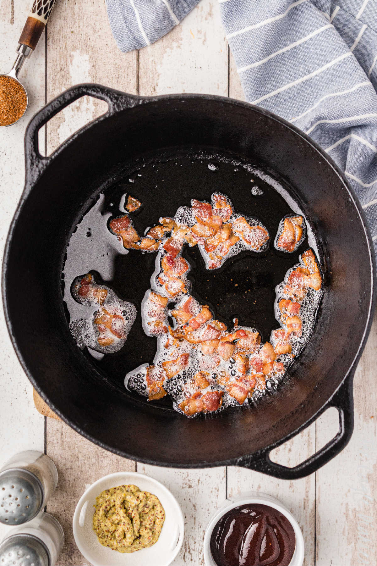 A cast iron pot with bacon cooking.