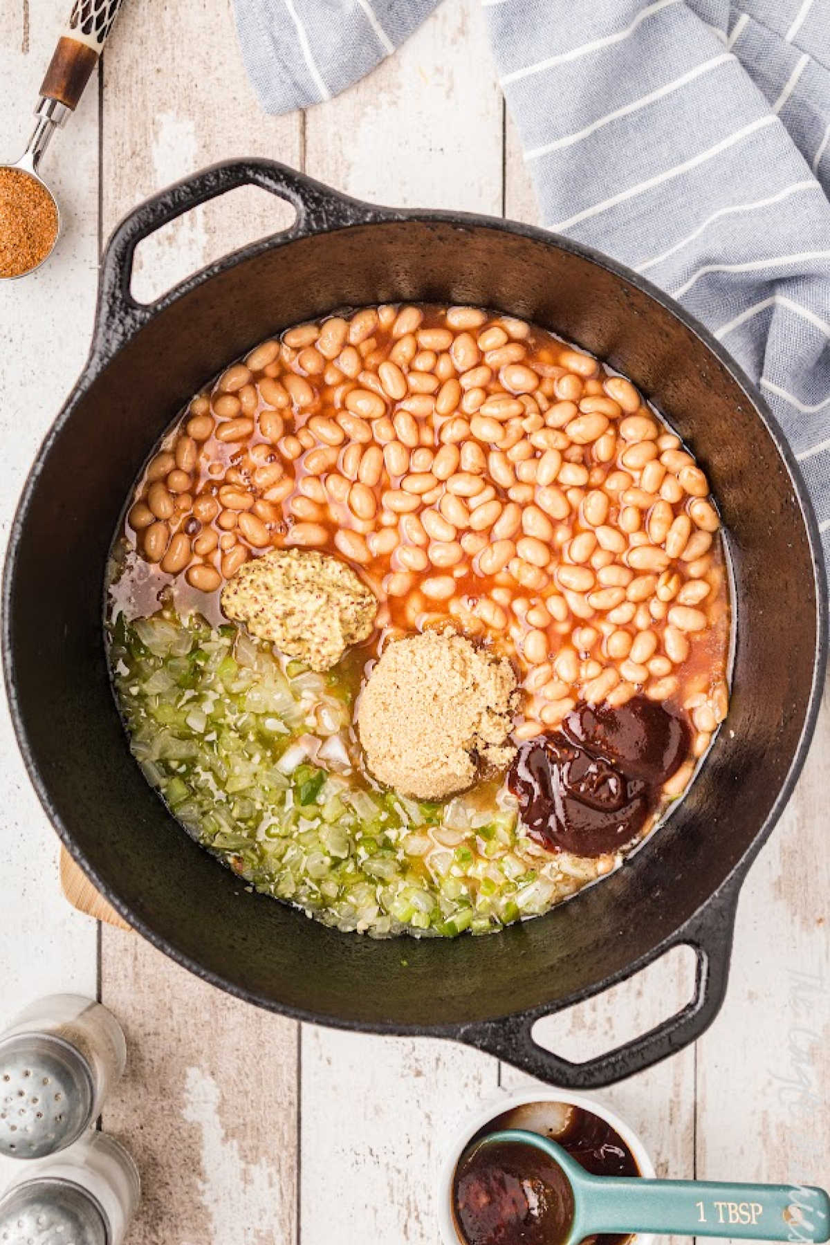 A cast iron pot with beans, greens and seasonings.