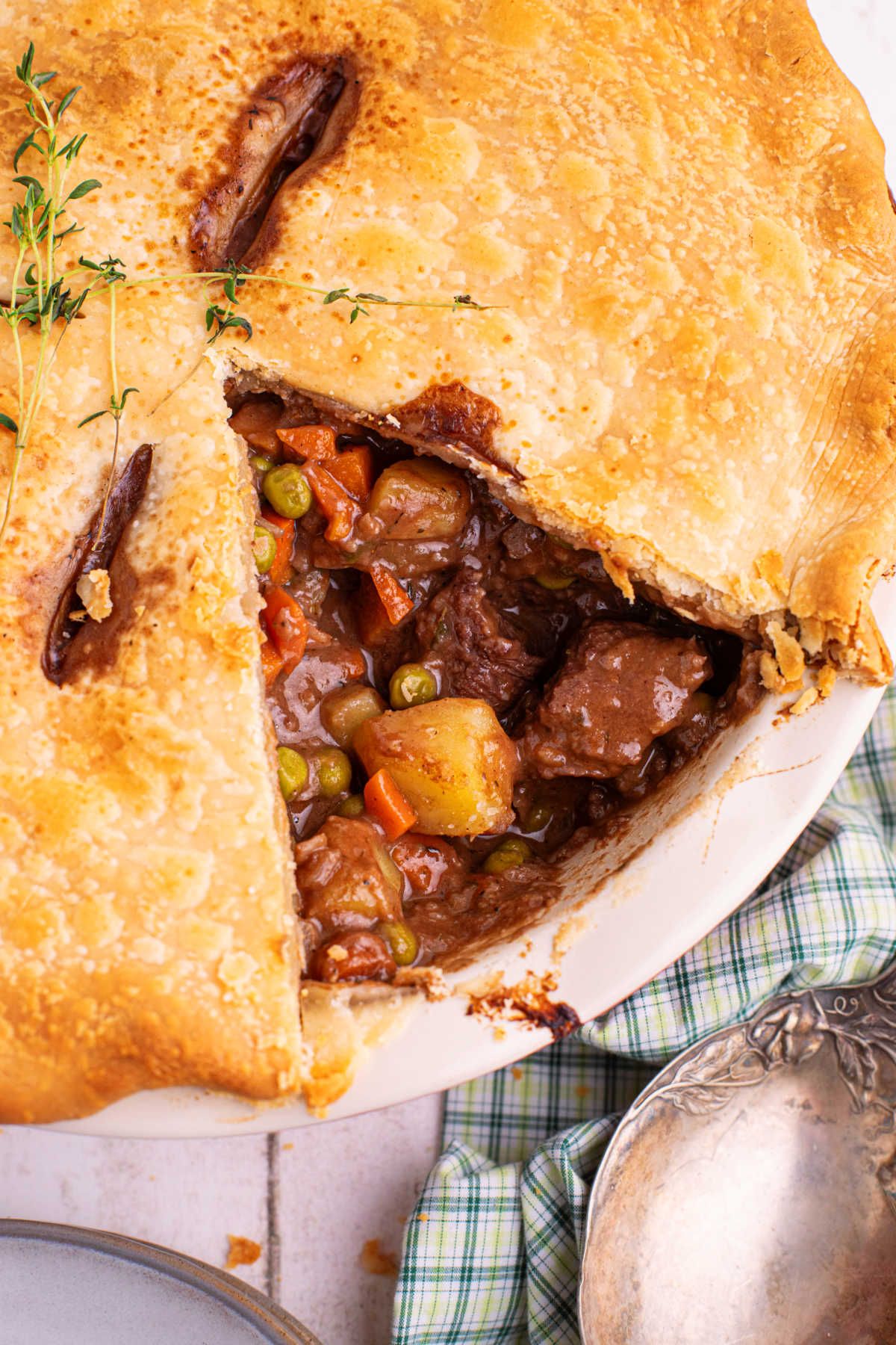 Portrait image of a beef pot pie with a slice missing.