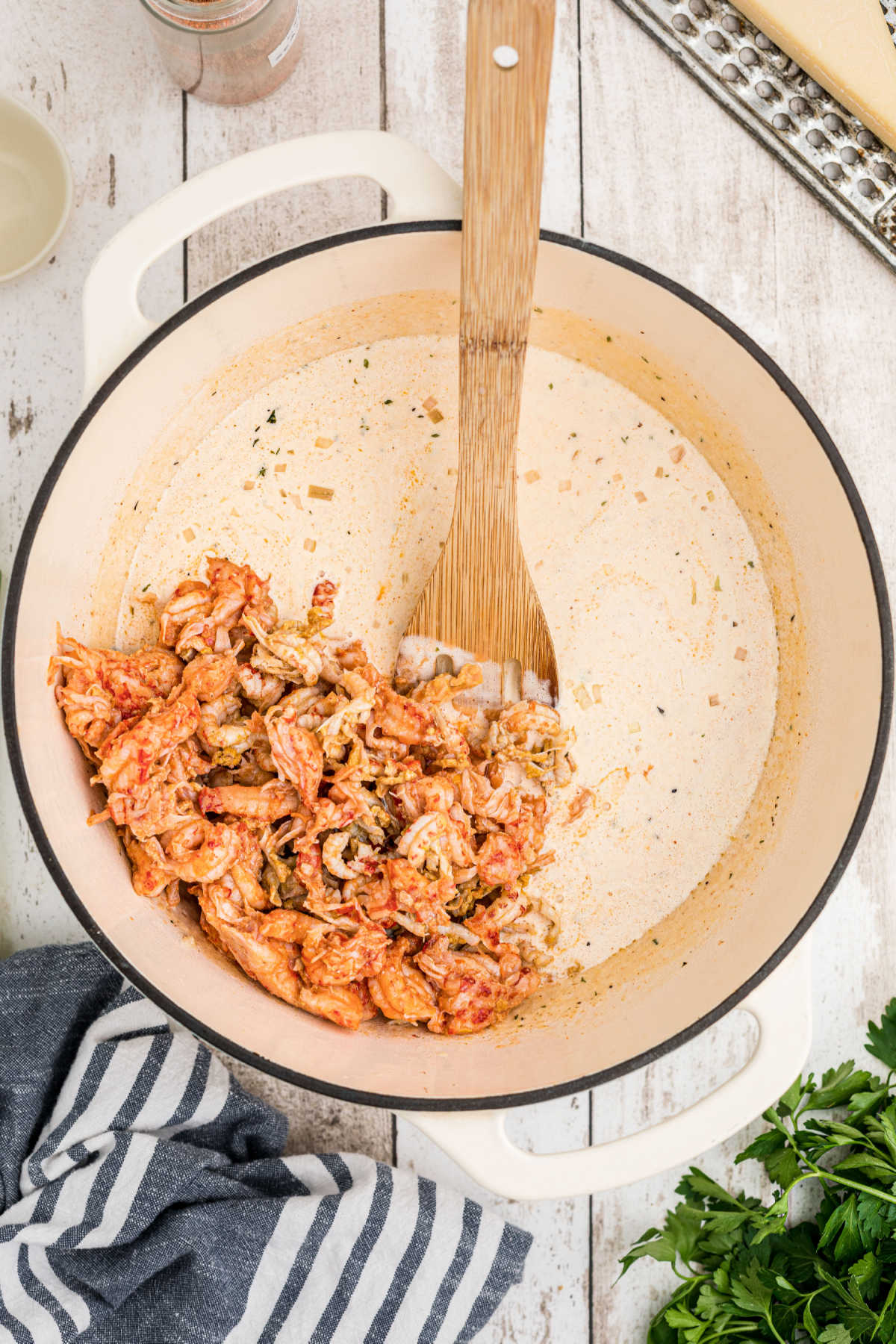 Peeled crawfish tails being added to a pot.