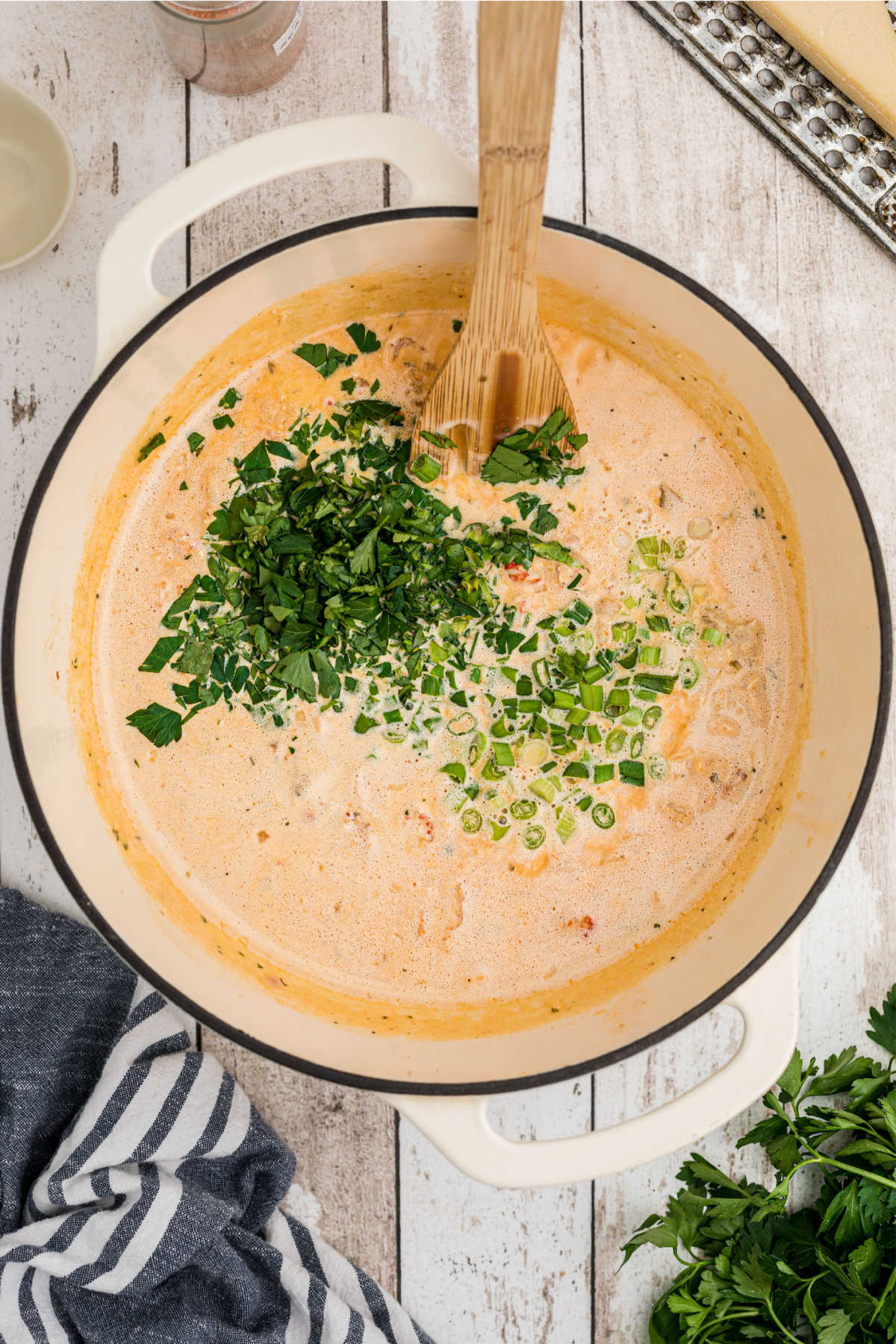 Parsley and green onions being added to sauce.