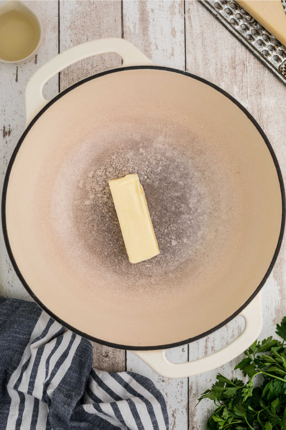 A large Dutch Oven with a stick of butter.