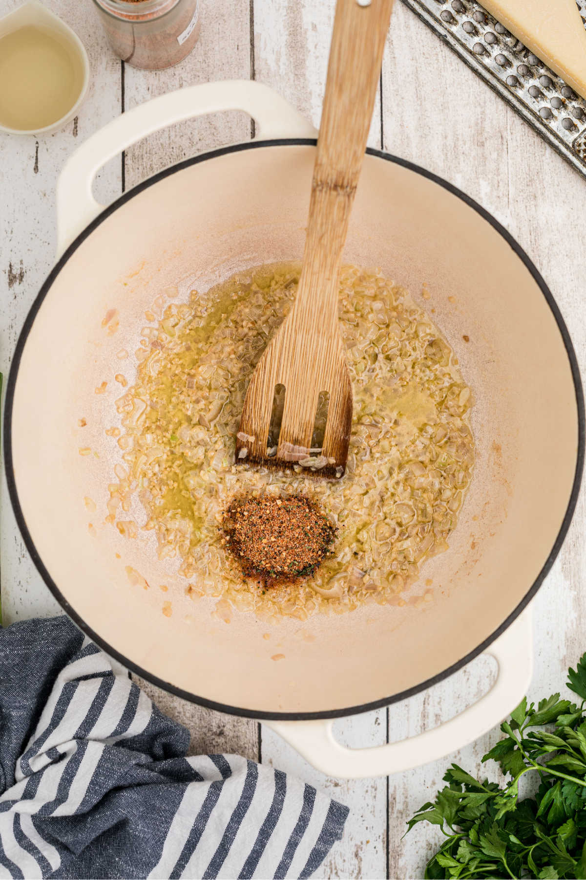 Seasonings added to a pot with shallots and garlic.