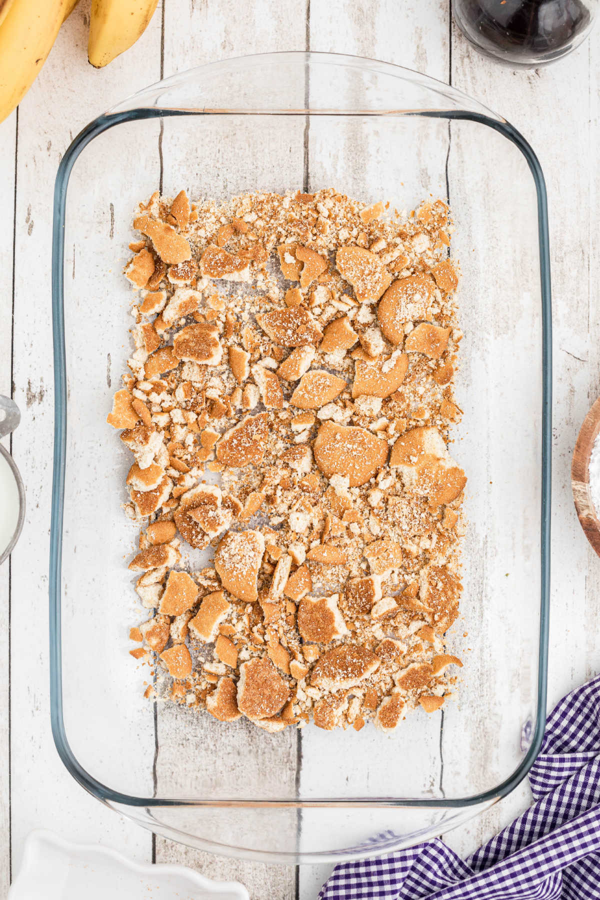 A baking dish with crushed vanilla wafers lining the bottom.