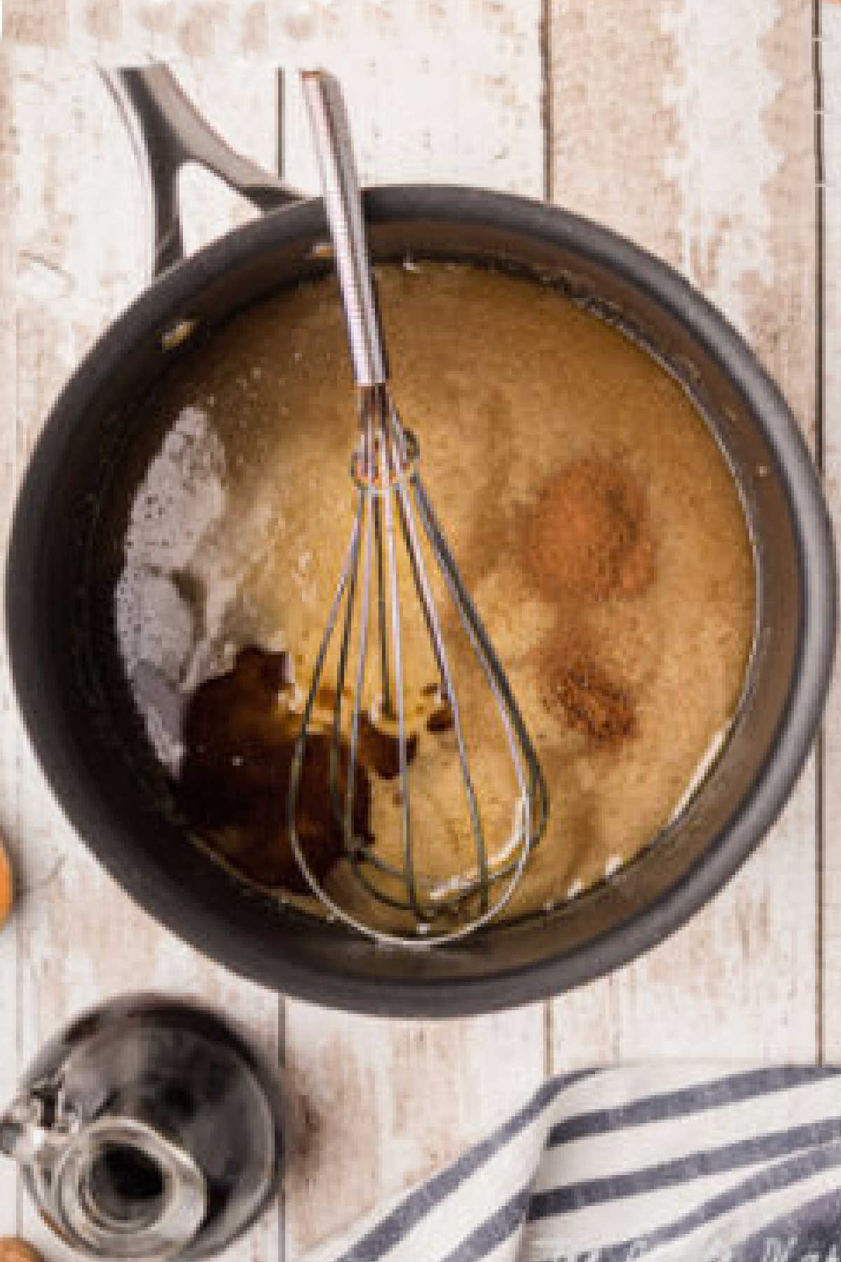 A whisk mixing in the remaining vanilla and spices.