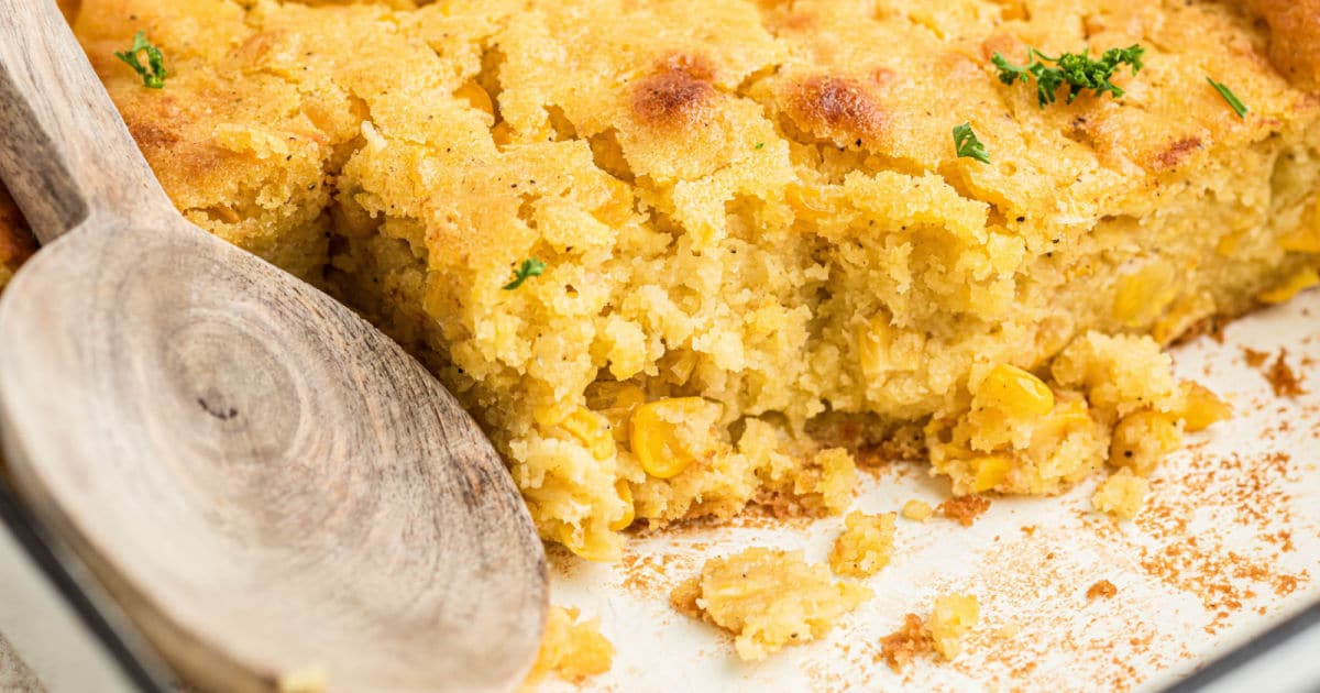 Close up of some cornbread pudding with a spoon resting.